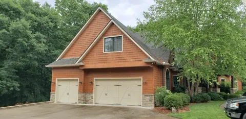 Aristocrat Monarch Series doors on a cedar-shake garage