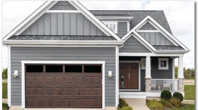 Walnut Safe-Way Plank Wood Grain garage door shown on a home